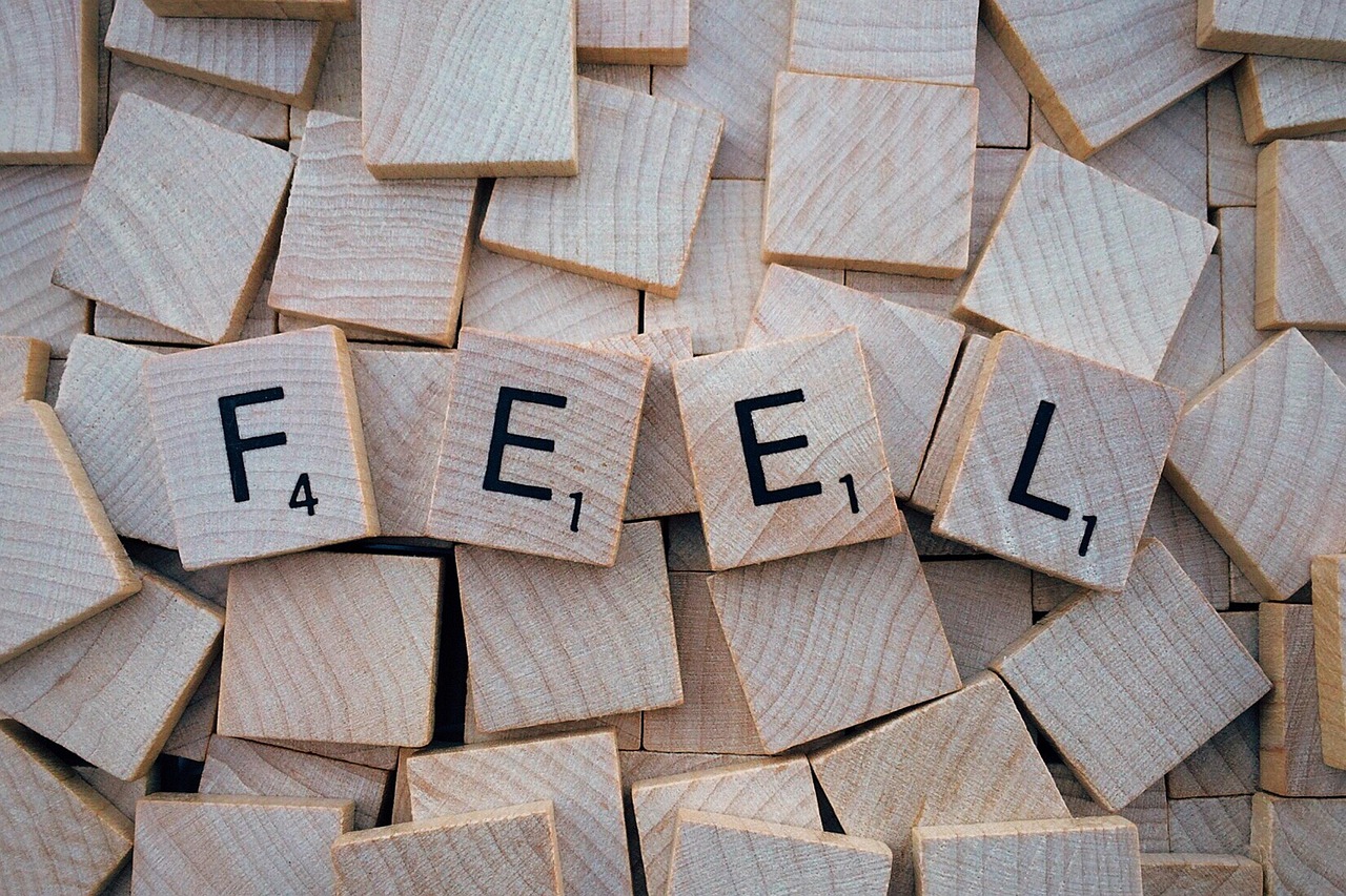 Scrabble tiles spelling out the word FEEL.