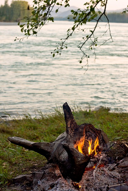 A lit campfire near a river.